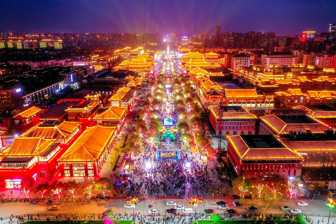 Illuminated traditional rooftops and a lively pedestrian avenue in Xi’an at night