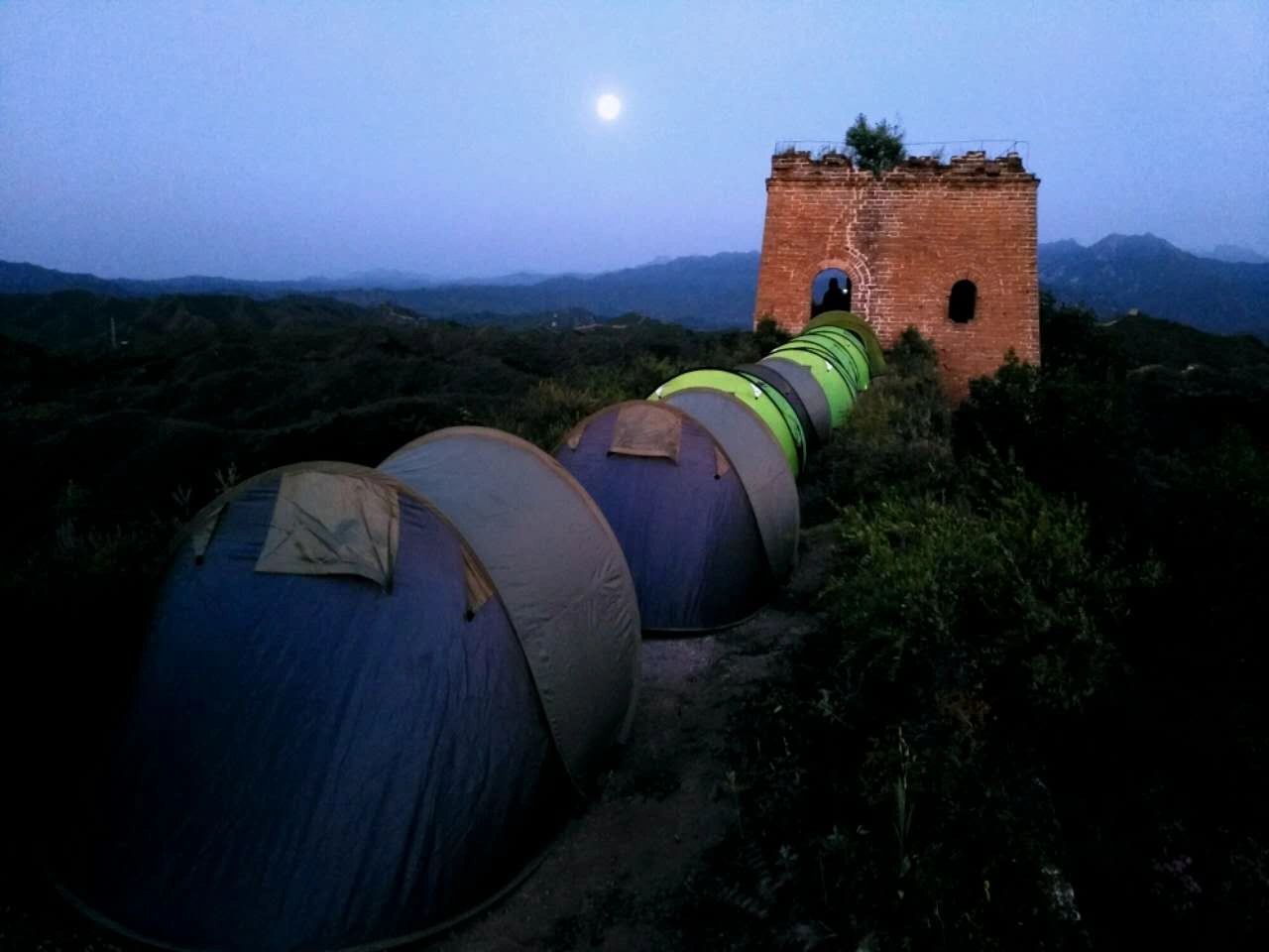 Great Wall Adventure Club tents beside a historic watchtower