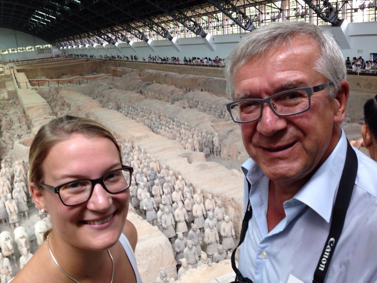 Two travelers taking a photo overlooking the Terracotta Army excavation hall