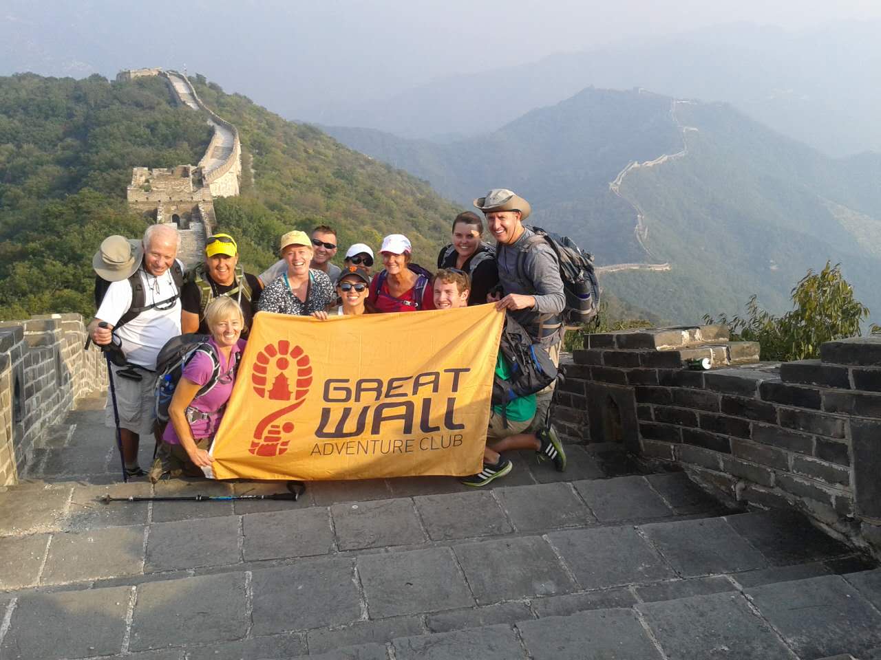 Hiking group holding a Great Wall Adventure Club banner on the Great Wall