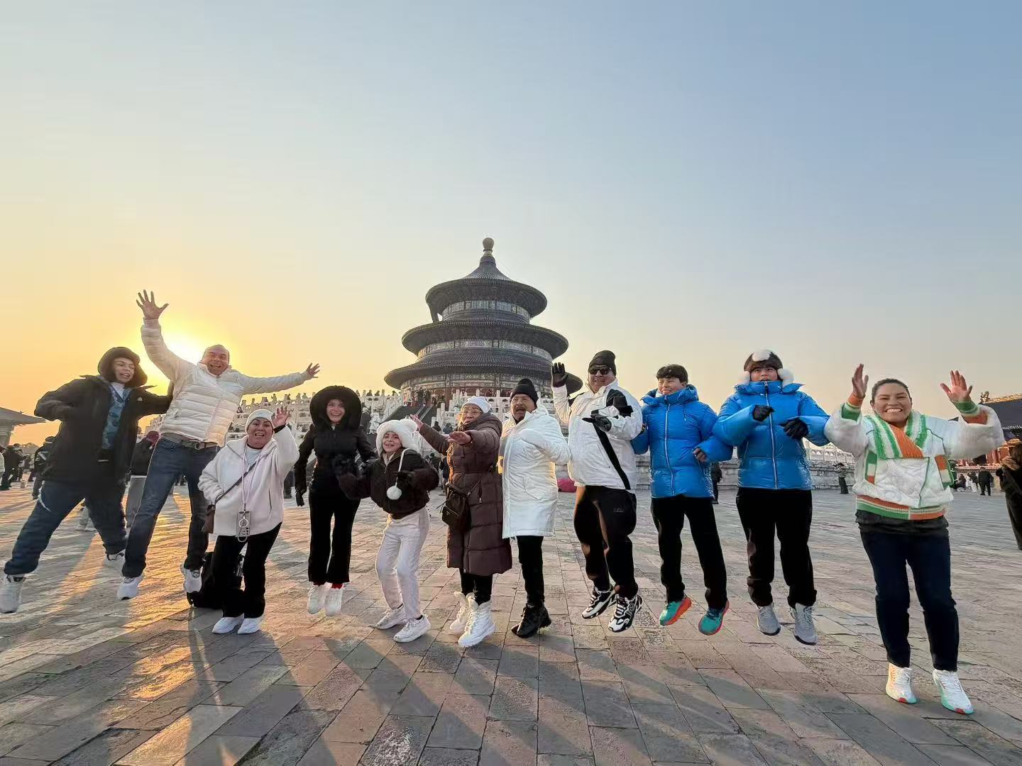 Traveler group jumping together in front of the Temple of Heaven at sunset